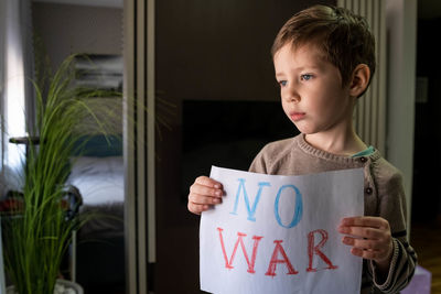 Boy holding poster at home