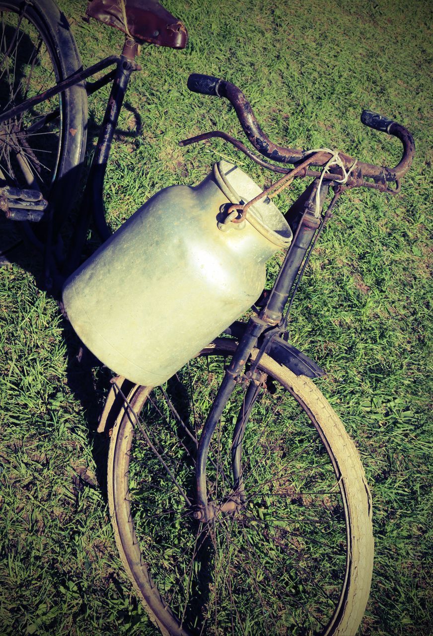 HIGH ANGLE VIEW OF BICYCLE WHEEL BY GRASS