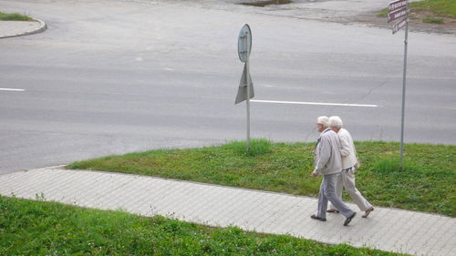 Rear view of man walking on footpath