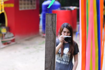 Woman photographing wooden post