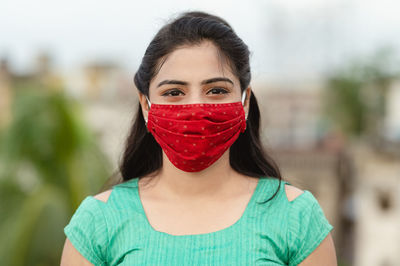 Close-up of woman wearing red mask