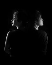 Rear view of two people against black background