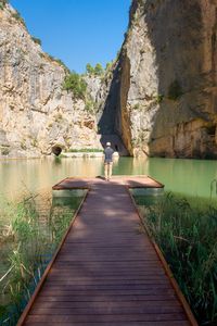 Woman standing on rock by mountain