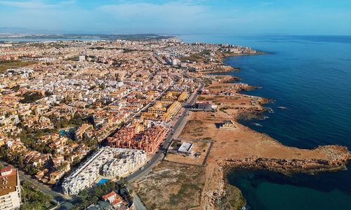 High angle view of townscape by sea against sky