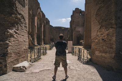 Rear view of man standing amidst buildings
