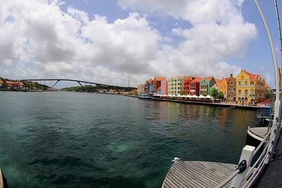 Bridge over river in city against sky