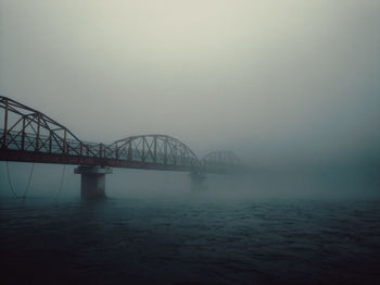 Bridge over river against sky during sunset