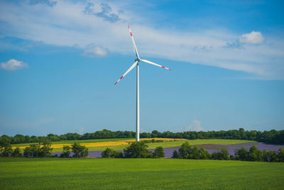 Windmill on field against sky