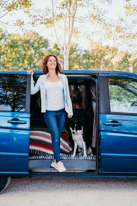 Woman with dog standing at entrance of camper trailer