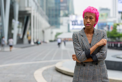 Portrait of woman standing on street in city