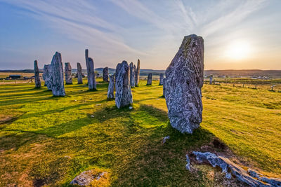 Panoramic view of rocks on landscape against sky during sunset