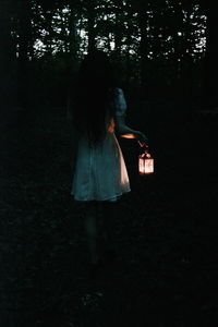 Rear view of woman walking in forest