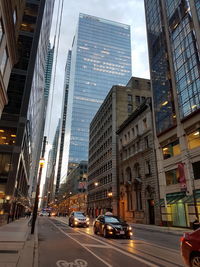 Cars on road amidst buildings in city