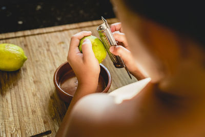 Midsection of woman holding fruit on table