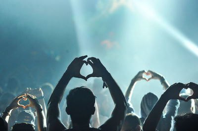 Rear view of men photographing against sky