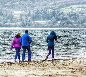 Rear view of friends standing on beach