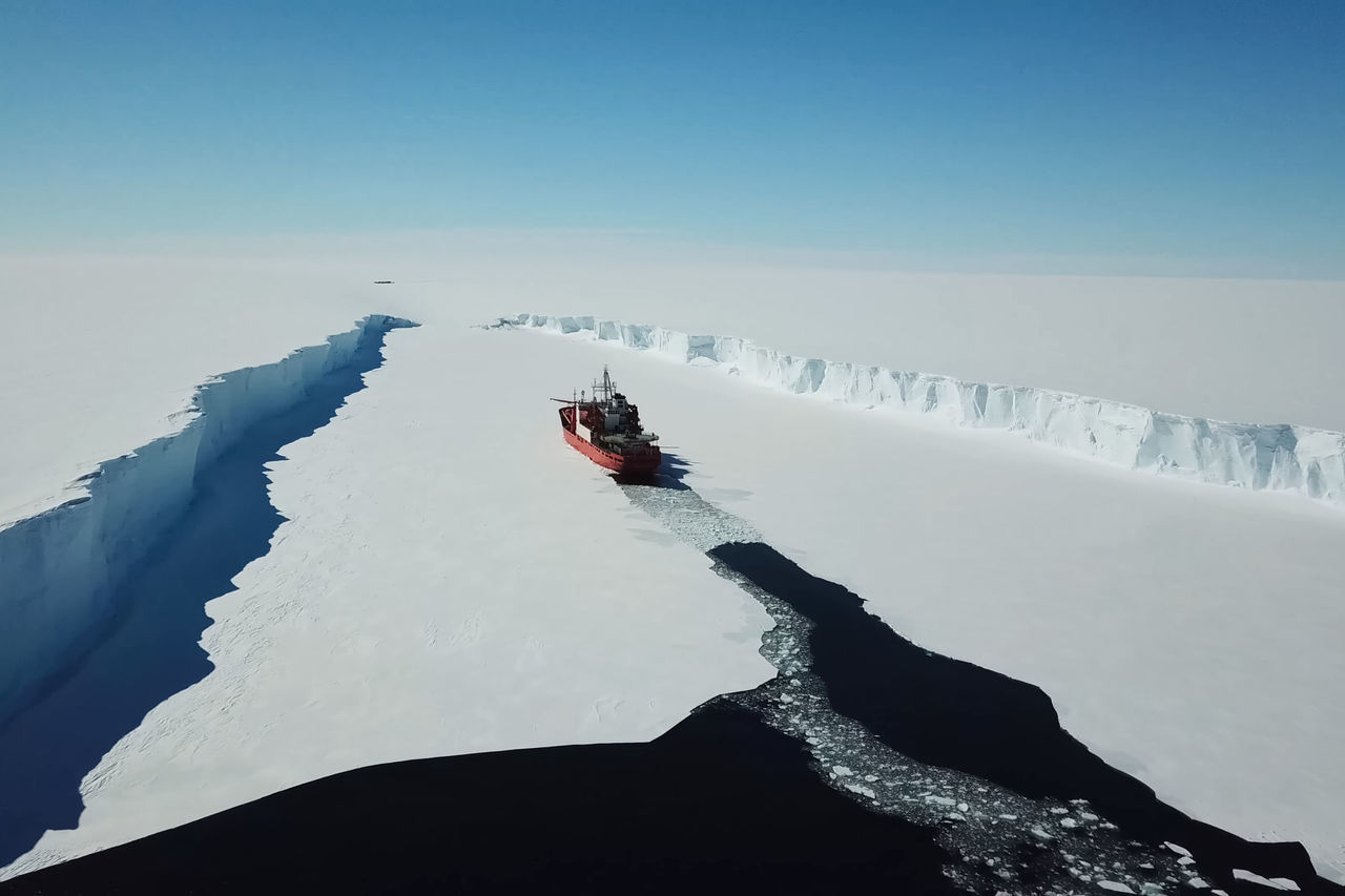 PERSON SKIING ON SNOWCAPPED MOUNTAIN AGAINST SKY