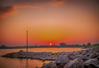 Scenic view of sea against orange sky