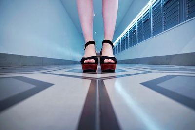 Low section of woman standing on corridor