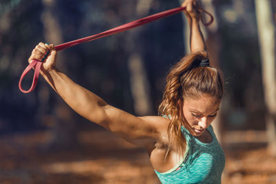 Female athlete exercising with resistance band at park