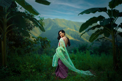 Full length of woman standing by tree