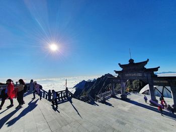 People at town square against clear blue sky