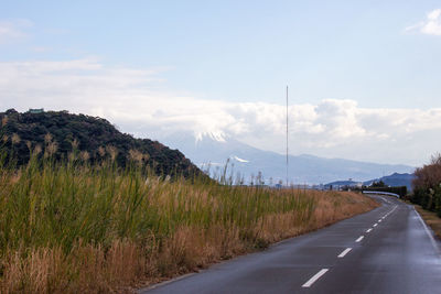 Road by mountain against sky