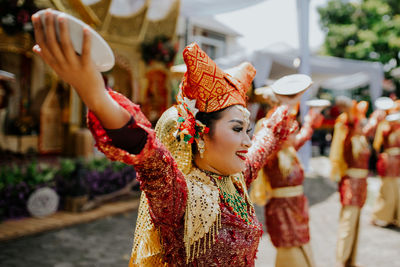 Midsection of woman holding flowers in market