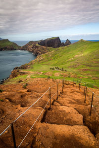 Scenic view of mountains and sea against cloudy sky