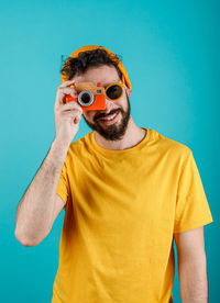 Portrait of young man standing against blue background