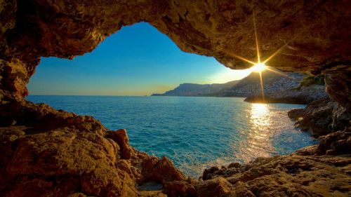 Scenic view of sea against sky seen through cave