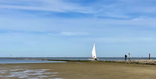 Sailboat on beach against sky