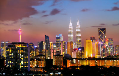 Illuminated cityscape against sky at night