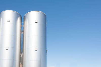 Low angle view of storage tanks against sky