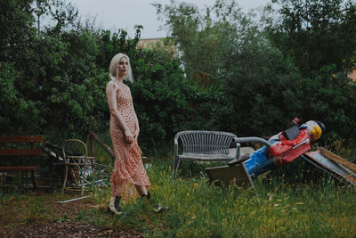 Portrait of young woman standing at park