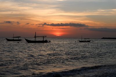 Silhouette boat in sea against sky during sunset