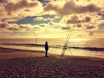 Scenic view of beach against cloudy sky