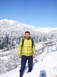 Portrait of woman standing on snowcapped mountain