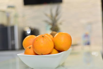 Close-up of orange fruits in bowl on table