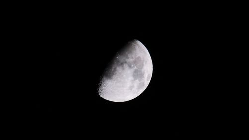 Low angle view of moon against dark sky