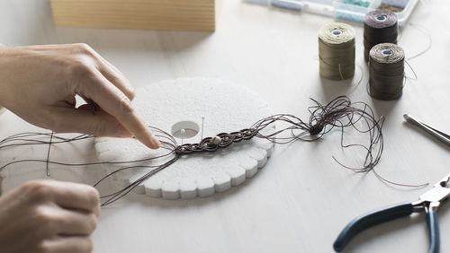 High angle view of woman working with thread on table