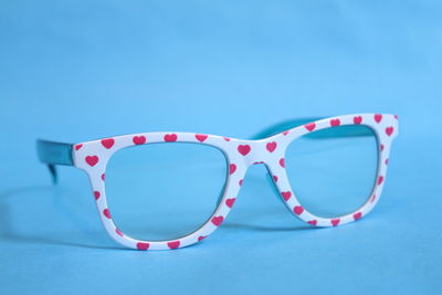 Close-up of eyeglasses against blue background