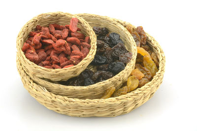 Close-up of dried food in basket against white background