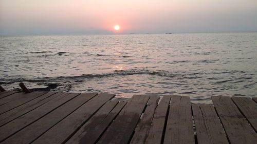 Wooden pier on sea at sunset