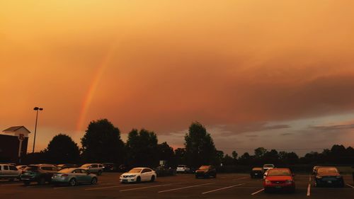 Cars on street against sky during sunset