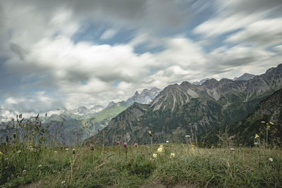 Scenic view of field and mountains against sky