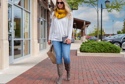 Woman wearing sunglasses walking on footpath