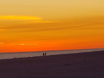 Scenic view of sea against orange sky