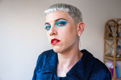 Portrait of young transgender man with makeup looking at camera