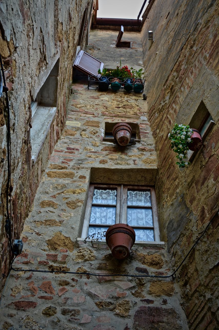 architecture, built structure, building exterior, house, low angle view, building, residential structure, wall - building feature, residential building, window, steps, potted plant, sunlight, day, door, no people, wall, outdoors, old, hanging